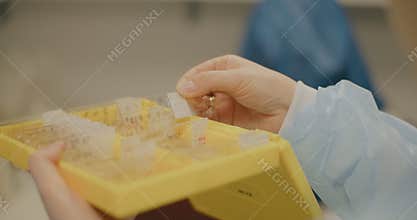 Woman Handling Test Tubes and Microscope Slides