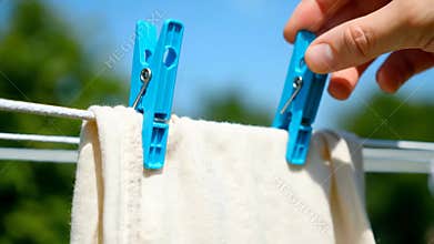Blue Clothespin Holds White Laundry on Clothesline Outdoors at Daytime
