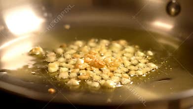 Frying Diced Garlic in Oil on a Pan to Prepare a Tasty Dish