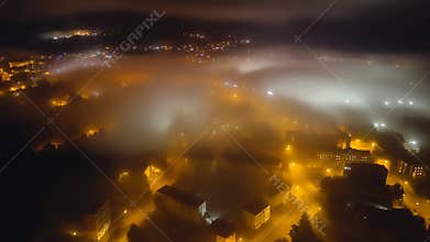 City lights glowing through dense fog at night
