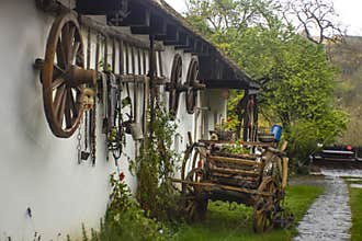 Traditional rural farmhouse with wooden cart and vintage tools