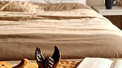 Cozy Bedroom Still Life with Open Book and Wooden Decoration on Bedside Table Featuring Natural Light and a Calm and Relaxing