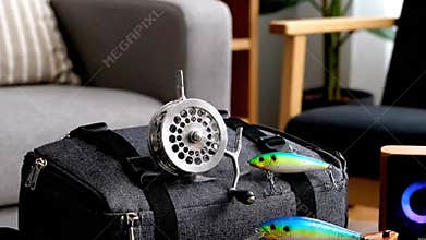 Fishing Reel Display on Gray Bag with Lures in Indoor Setting Featuring Light and Airy Interior Design Elements and Decorative