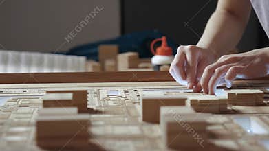 Hands of Professional Man Constructing Architecture Model of Urban City Building