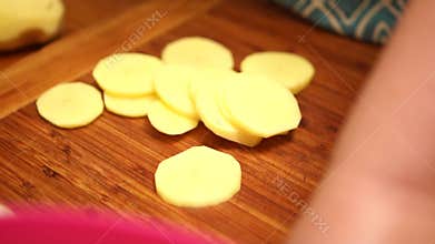 Slicing vegetables potato. Female hands cut carrot on a wooden cutting board. Cooking in the kitchen. Food preparation. Close-up.
