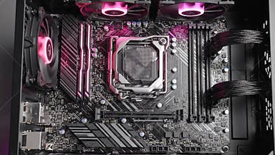 Detailed Top View of a Computer Motherboard with Glowing Blue LED Fans and RAM Slots in a Computer Case Illuminated for Technology