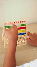 Child learning to count on a colorful wooden abacus