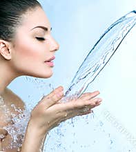 Smiling model girl under splash of water