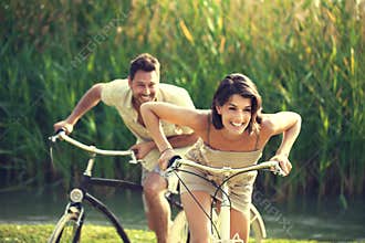 Couple having a bicycles race into the nature in Garda Lake
