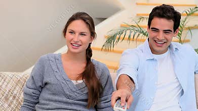 Man and woman sitting on the couch watching TV