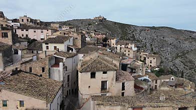 A cinematic drone flight over the historic old town of Bocairent, Spain, showcasing traditional stone houses built into