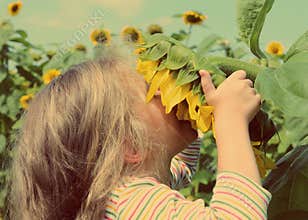 Little girl smelling sunflower - vintage retro style