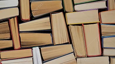 Stacked hardcover books viewed from above showing page edges and bindings