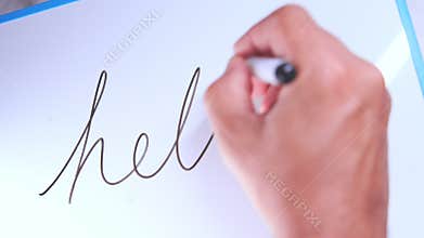 Hand writing cursive hello on whiteboard
