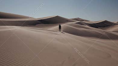 Explorer travels onward, Individual moves across deserts, Adventurer ventures through sweeping sandy terrains, Wanderer