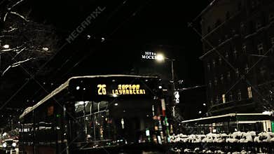 Buses and cars move along a snowy street near Hotel Moskva during winter night traffic in Belgrade. Belgrade, Serbia 9 January