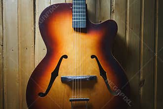 Details of an old jazz guitar on a wooden wall