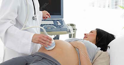 Brunette pregnant woman having a sonogram scan