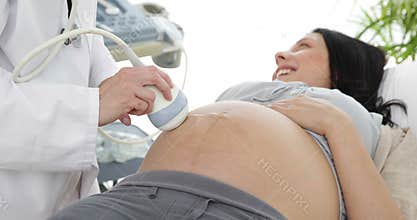 Brunette pregnant woman having a sonogram scan