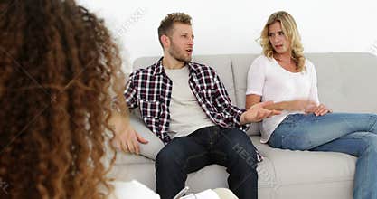 Arguing young couple sitting on couch