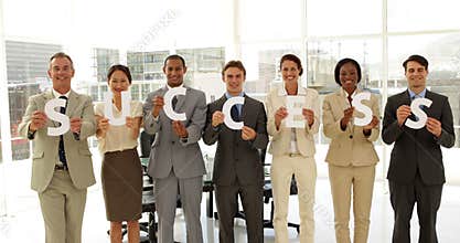 Business people holding letters spelling success