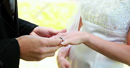 Bride and groom exchanging wedding rings