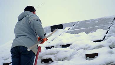 A man clears snow from solar panels. Selective focus.