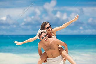 Couple having fun on the beach of a tropical ocean.
