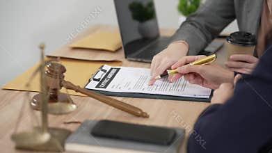 A young, professional Asian female lawyer is advising and consulting female clients, discussing legal contracts