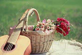 Guitar, basket and bouquet of flowers. Vintage tender background