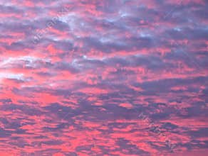 Colorful sunset sky with pink and purple clouds over a tranquil evening landscape