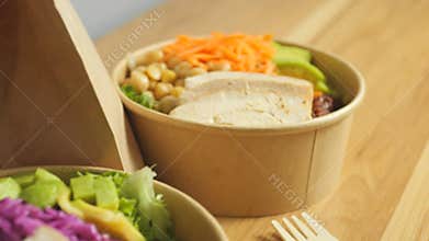 Preparing nutritious buddha bowls featuring grilled chicken, roasted chickpeas, creamy avocado, brown rice, vibrant carrots