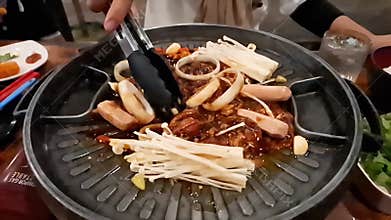 Slow Motion Close-up of Stir-Frying Marinated BBQ Meats, Mushrooms, and Onions