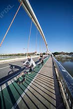 Seville, Spain, Dec 29 2021, Cyclists enjoy the green bike lane on Barqueta Bridge in Seville