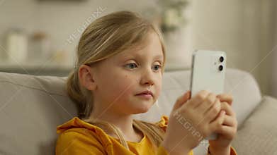 Caucasian little child kid girl holding mobile phone feeling shock say wow open mouth excited amazed surprised reaction