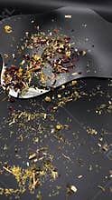 Herbal tea blend with chamomile, melissa, and hibiscus on black background