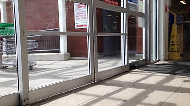People with Shopping Cart Walking Through the Doors
