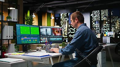 Green screen next to videographer cutting and editing video footage