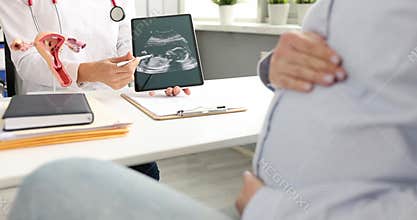 Doctor shows ultrasound image to pregnant woman and explains