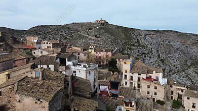 Drone flew past an old abandoned city without people to a mountain with a historic castle,