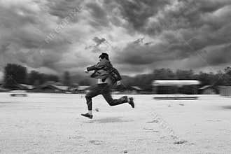 Business man runing in the beach. Motion blur