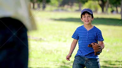Smiling boy playing baseball while standing upright