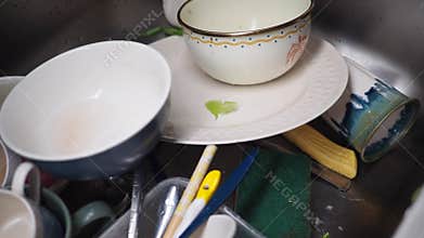 Messy kitchen sink with dirty dishes and utensils