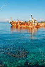 Rusty the Edro III Shipwreck, Pegeia, Cyprus, in turquoise waters by shoreline under clear sky