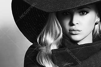 Monochrome portrait of Beautiful Blond Woman in Black Hat. Fashionable Lady in Topcoat