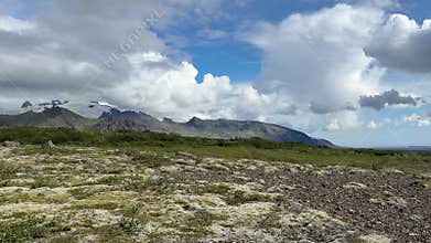 Expansive Green Highland Plain with Distant Snow-Capped Mountains in Iceland