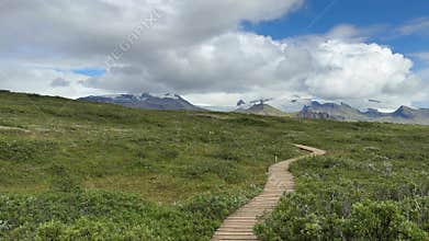 Long Boardwalk Trail Across Expansive Green Plain in Iceland