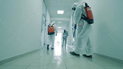 Cleaners disinfect a hallway in office building to kill coronavirus.