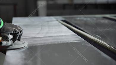 Steel Polishing. Man Polishes a Metal Cover
