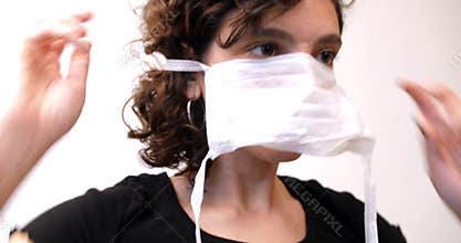 Young woman putting on a face mask to prevent viral contagion